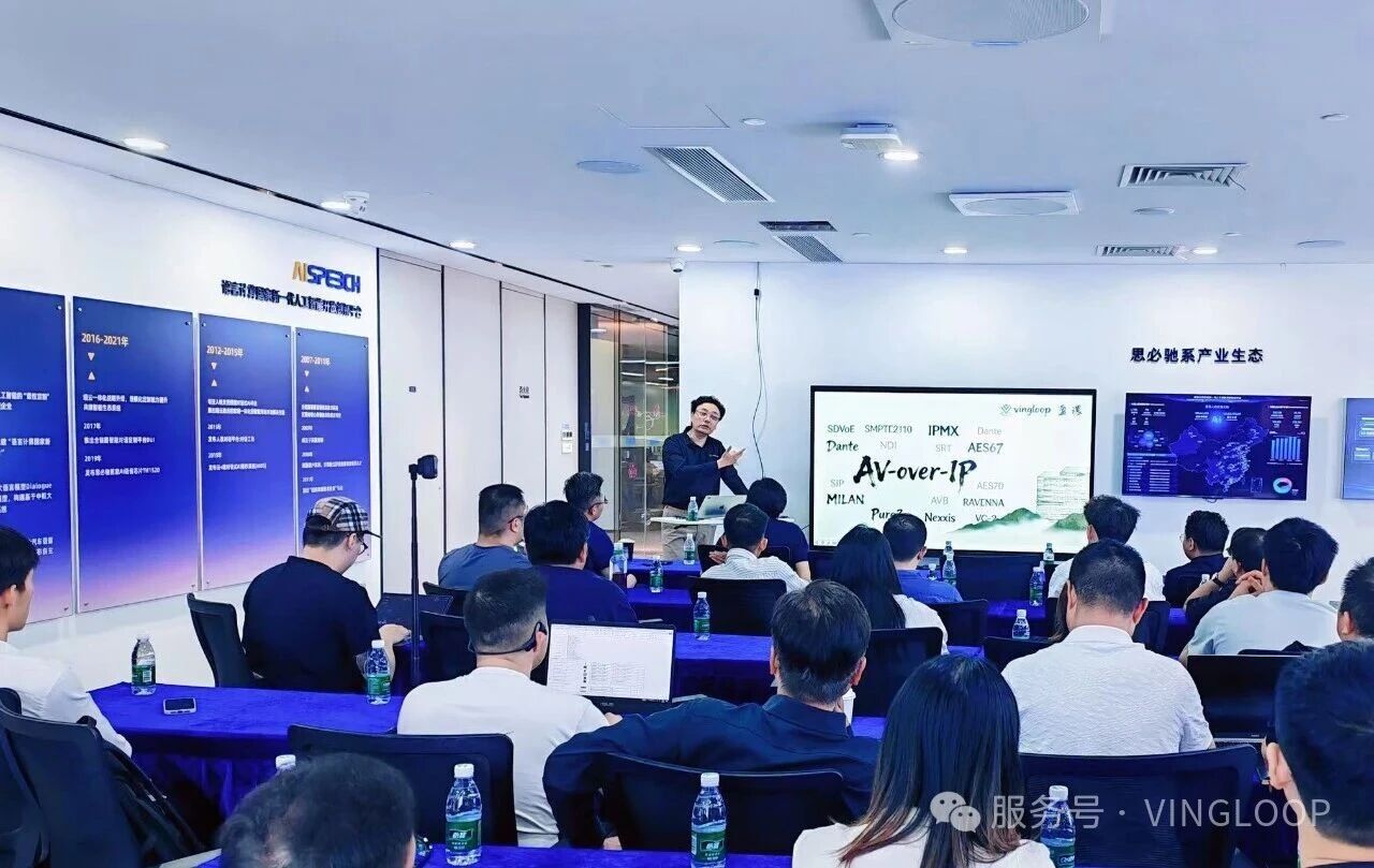VINGLOOP AV-over-IP national roadshow training session with a presenter and attendees in a showroom.
